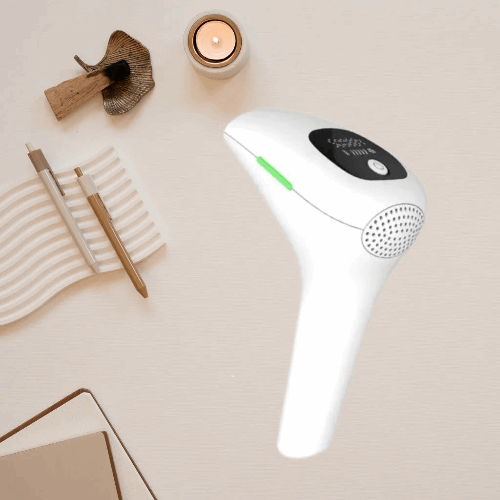 White IPL light grooming hair removal device with a green light on a beige surface
